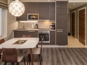 a kitchen with a table and chairs in a room at Holiday Home Tahko spa red - golf apartment by Interhome in Tahkovuori