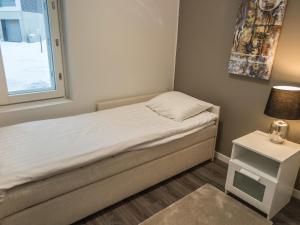 a small bedroom with a bed and a window at Holiday Home Tahko spa red - golf apartment by Interhome in Tahkovuori