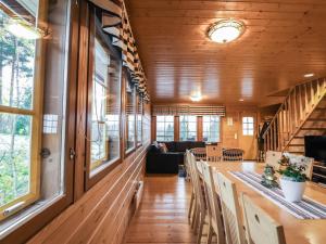 ein Esszimmer mit einem langen Tisch und Fenstern in der Unterkunft Holiday Home Dominus by Interhome in Böle