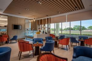 卢萨卡Neelkanth Sarovar Premiere的有桌椅和酒吧的餐厅