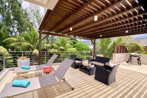 an outdoor patio with a wooden pergola at Bon Azur Beachfront Suites & Penthouses by LOV in Trou aux Biches