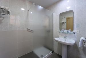 a bathroom with a shower, sink, and mirror at Hotel Sur Málaga in Málaga