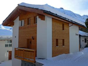 サースフェーにあるApartment Chalet Saasia by Interhomeの雪の中のデッキ付きの家