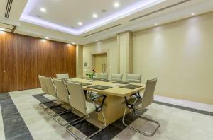 a conference room with a long table and chairs at TADJ EL MAOUADA in Sétif