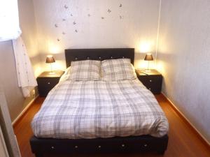 a bedroom with a bed with two lamps on two tables at 18 Résidence Parc de la Dune in Lacanau