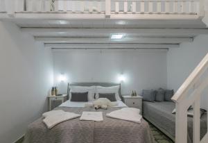 un orsacchiotto che giace su un letto in una camera da letto di Uncle's House luxury Suites ad Adámas