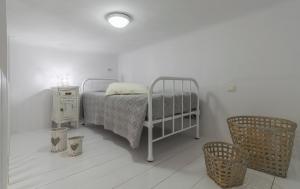 una camera bianca con letto e comodino di Uncle's House luxury Suites ad Adámas