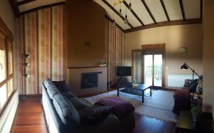 sala de estar con sofá y chimenea en Casa Loisiana en O Pino 