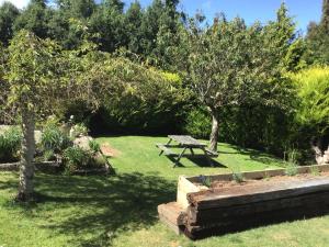 a picnic table in a garden with trees and grass at Self contained and private room in Dunedin