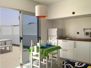 una cucina con tavolo e sedie verdi di Sunny Studio Lanzarote a Charco del Palo