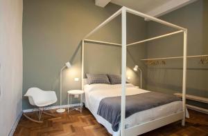 een slaapkamer met een wit hemelbed en een stoel bij Casa Iolanda in Mantova