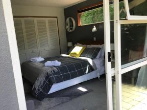 1 dormitorio con 1 cama con 2 toallas en Self contained and private room en Dunedin