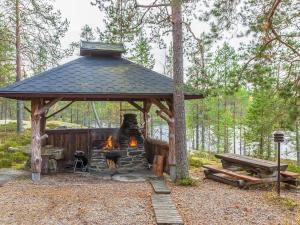 a gazebo with a fireplace in the woods at Holiday Home Huljakka by Interhome in Lipinlahti