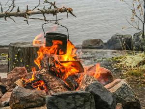 een kampvuur met een pot erop bij Holiday Home Huljakka by Interhome in Lipinlahti