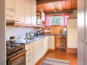a kitchen with white cabinets and a stove top oven at Holiday Home Viehko by Interhome in Lipinlahti