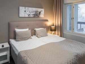 a bedroom with a bed with white sheets and a window at Holiday Home Tahko spa red - vuori apartment by Interhome in Tahkovuori