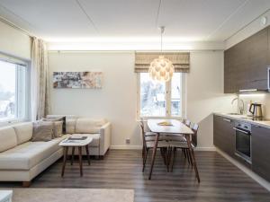 a living room with a couch and a table at Holiday Home Tahko spa red - vuori apartment by Interhome in Tahkovuori