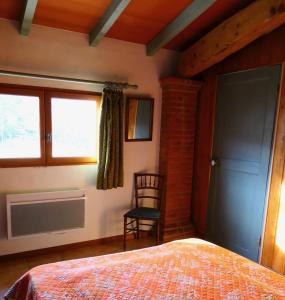 1 dormitorio con 1 cama, 1 silla y 1 ventana en Coutelon, havre de paix en pleine nature en Saint-Jurs