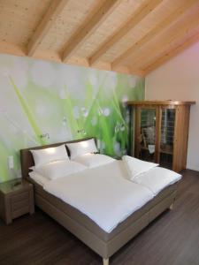 ein Bett in einem Schlafzimmer mit einer grünen Wand in der Unterkunft Pension Kainzer Sölde in Velden