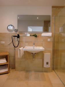 a bathroom with a sink and a mirror at Pension Kainzer Sölde in Velden