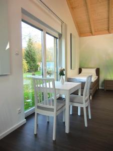 una mesa y sillas blancas en una habitación con ventana en Pension Kainzer Sölde en Velden