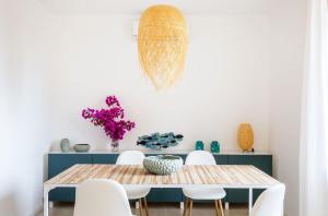 a dining room with a table and white chairs at La Matrangela Charme Apartments in Taormina