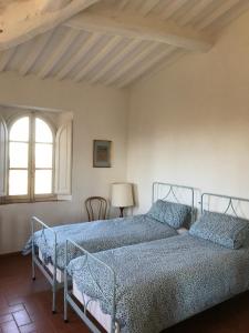 シエナにあるvilla montalcino palazzina castelverdelliのベッドルーム1室(ベッド2台、窓付)