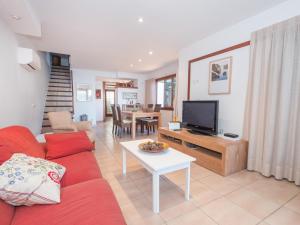 ein Wohnzimmer mit einem roten Sofa und einem TV in der Unterkunft Holiday Home Es clot by Interhome in Alcúdia