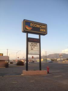 una señal para una posada económica en un estacionamiento en Economy Inn Alamogordo, en Alamogordo