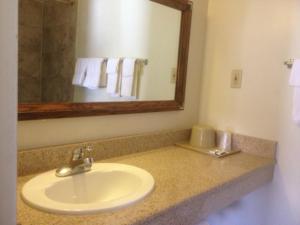 a bathroom with a sink and a mirror at Economy Inn Alamogordo in Alamogordo