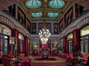 a large room with a chandelier and tables and chairs at Pera Palace Hotel in Istanbul