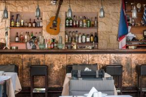 a restaurant with a bar with tables and a guitar at Minos Village in Agia Marina Nea Kydonias
