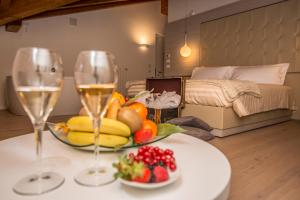 una mesa con dos copas de vino y un tazón de fruta en White Angel Hotel, en Breuil-Cervinia