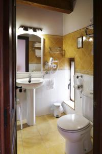 Un baño con un inodoro blanco y un lavabo. en Hotel Rural La Puebla, en Orbaneja del Castillo 37 fotos más