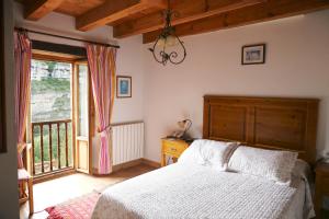 Un dormitorio con una cama y una ventana grande. en Hotel Rural La Puebla, en Orbaneja del Castillo