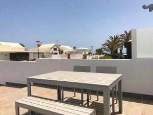 una mesa y un banco en la azotea en Sunny Studio Lanzarote, en Charco del Palo