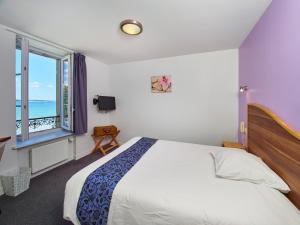 A bed or beds in a room at Logis Hotel Belle-Vue