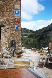 un patio con sillas y un edificio de ladrillo con chimenea en Hotel Rural La Puebla, en Orbaneja del Castillo