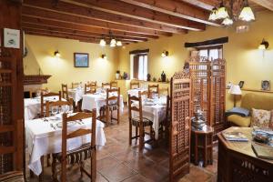 Un restaurante con mesas y sillas en una habitación. en Hotel Rural La Puebla, en Orbaneja del Castillo