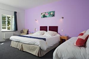 A bed or beds in a room at Logis Hotel Belle-Vue