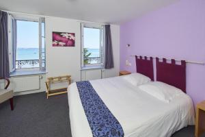 A bed or beds in a room at Logis Hotel Belle-Vue