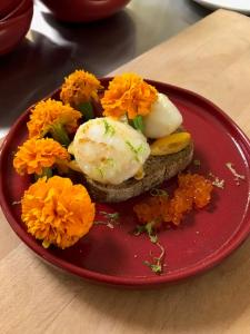 a red plate with a piece of bread with flowers on it at Le Ristolas in Ristolas