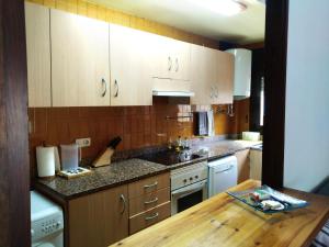 a kitchen with wooden cabinets and a wooden table at Apartament a Alp de Cerdanya in Alp