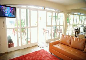 a living room with a couch and a flat screen tv at Residencial Aconchego in Socorro