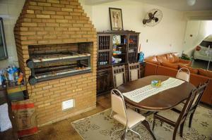 ein Wohnzimmer mit einem Tisch und einem gemauerten Kamin in der Unterkunft Residencial Aconchego in Socorro