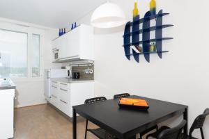 トゥルクにあるApartment Turku City Center host by B&B Tuureの黒いダイニングテーブルと椅子のあるキッチン