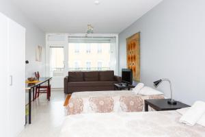 トゥルクにあるApartment Turku City Center host by B&B Tuureのベッド2台とソファのあるリビングルーム