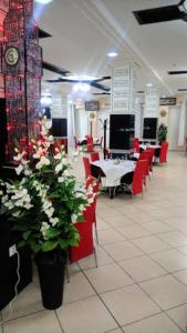 奧蘭的住宿－MARAVAL，用餐室设有红色的椅子和桌子,并鲜花盛开
