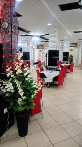ein Esszimmer mit roten Stühlen und Tischen und Blumen in der Unterkunft MARAVAL in Oran