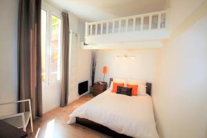 a bedroom with a bed with orange pillows at Coeur de Cannes Forville - Vieux Port Palais Plage in Cannes